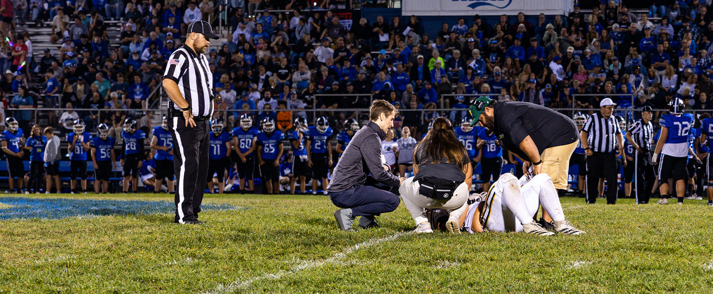 Reid Health Sports Medicine Dr. Connor Hoban and Athletic Trainer Hannah Cupp tending to an injured athlete. 