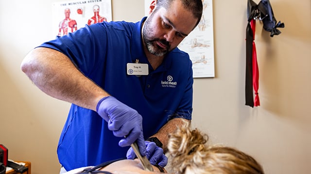 Trey Hollar, Athletic Trainer working on a patient in the Athletic Training Clinic
