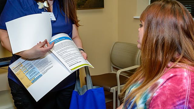 A Reid Health Perioperative clinic team member showing a patients helpful information