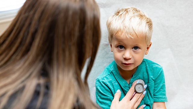 A young boy having his vitals checked by a nurse