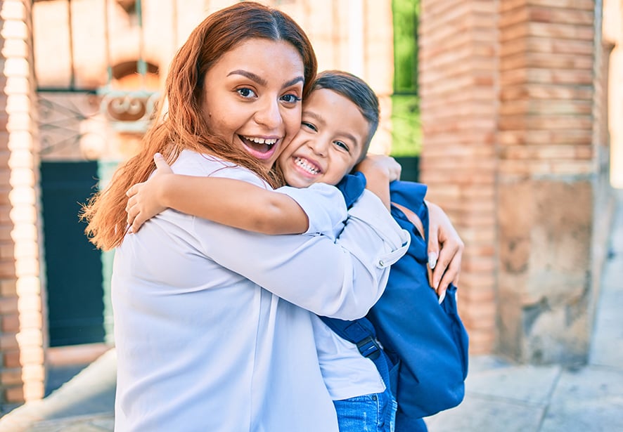 Latin student boy and mom hugging