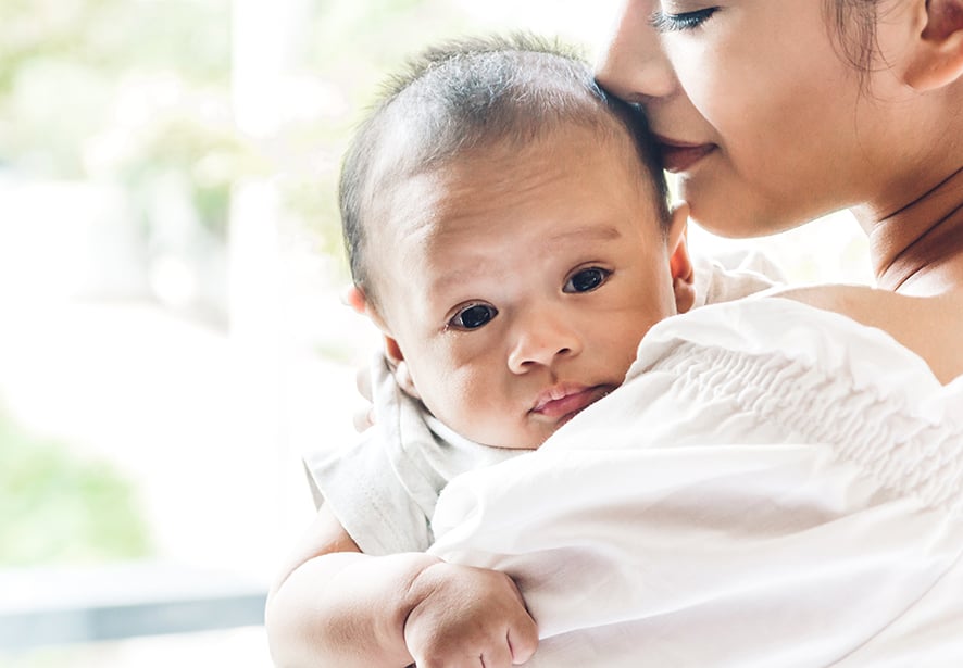 Mother kiss and holding baby in her arms