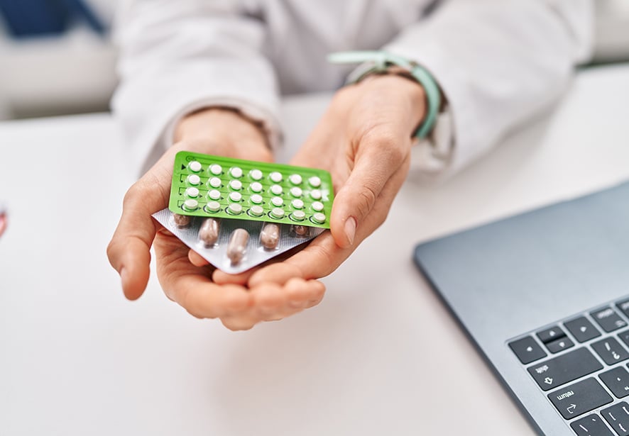 A woman holding birth control options