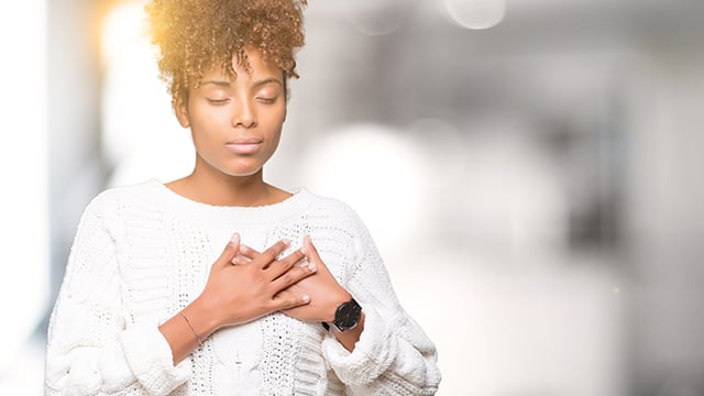 young african american woman wearing sweater, smiling with hands on chest with closed eyes