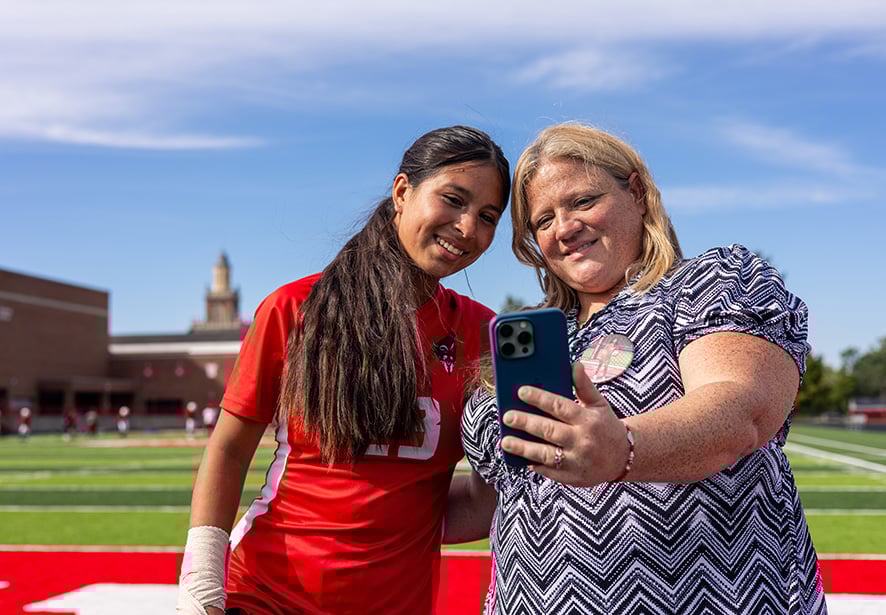A mom and her daughter looking at the mom's phone togther