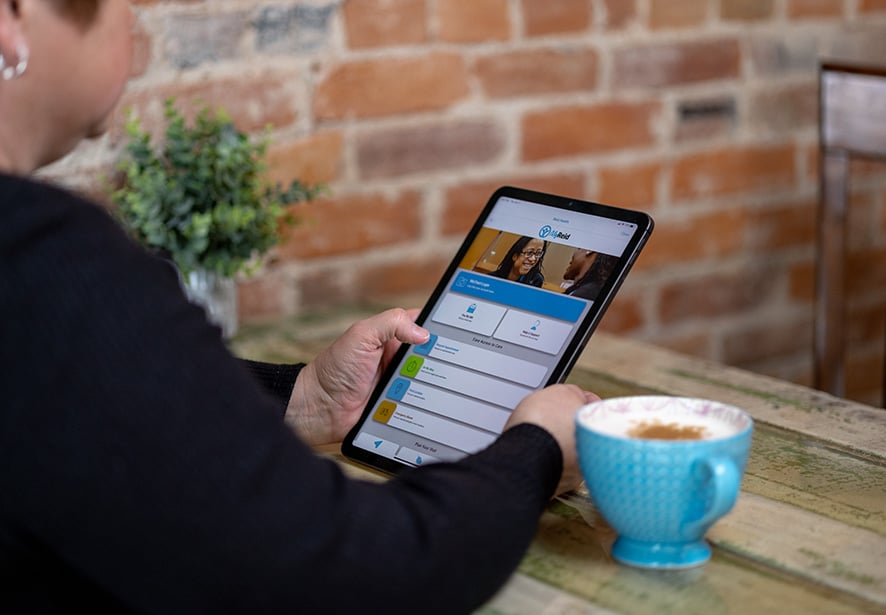 A women in a coffee shop using the MyReid App 