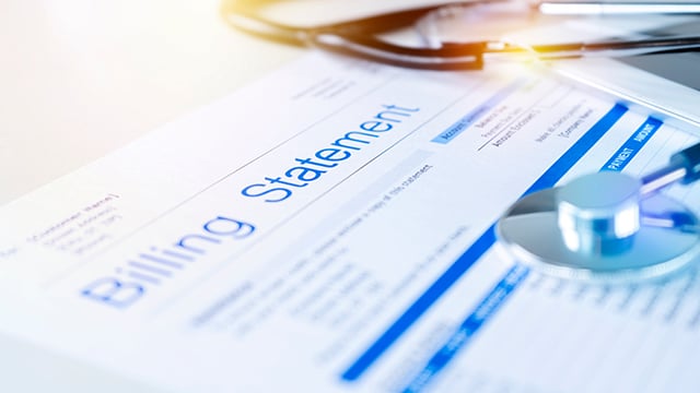 A billing statement with a stethoscope laying on it
