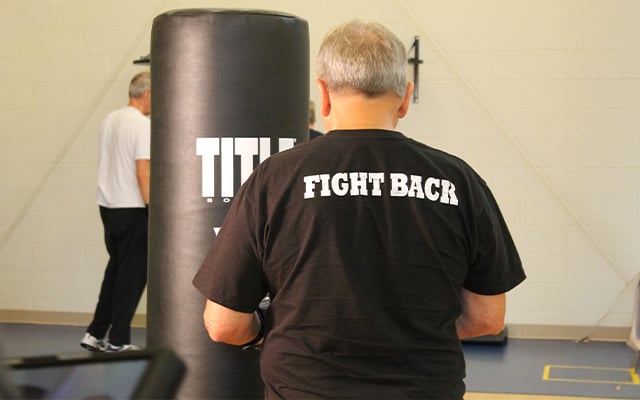 A participant in boxing class working out on the bag.
