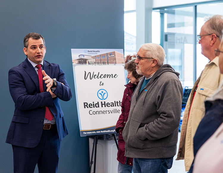 Reid Health CEO, Ben Wells speaking with a group during the opening house at Reid Health Connersville location