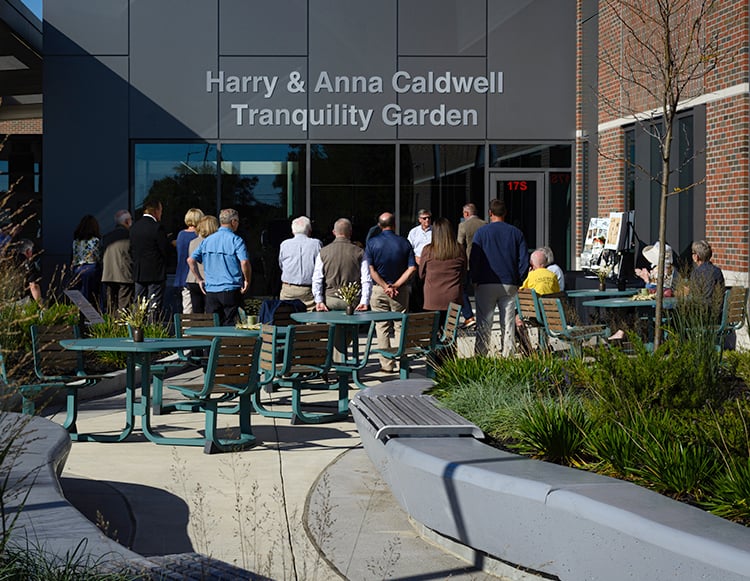An outside view of the Harry and Anna Caldwell Tranquility Garden with a crowd gathering at the dedication ceremony on September 29, 2026 at Reid Health Connersville.