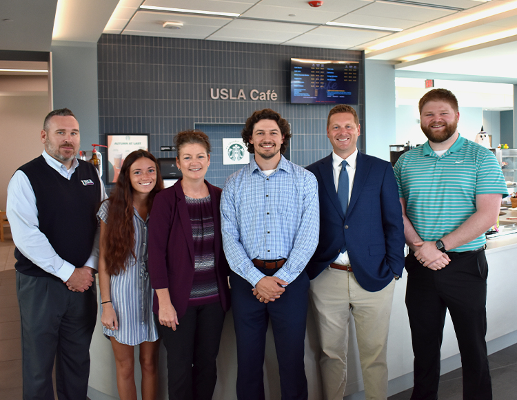 Six members from Union Savings & Loan Association standing in front the of USLA Cafe at Reid Health Connersville.