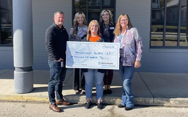Members of the Reid Health Community Engagement Team presenting a check to The Nest.