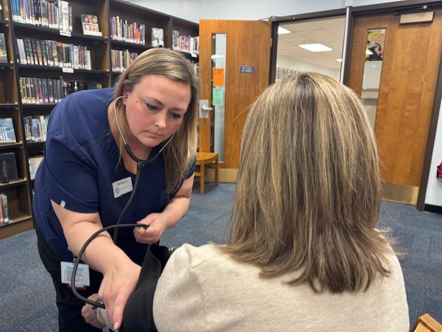 Ashley Shepard, Community Health Worker administering a preventive health check on a community member. 