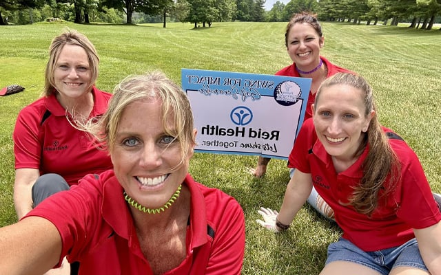 Four members of the Reid team participating in the swing for impact golf scramble 