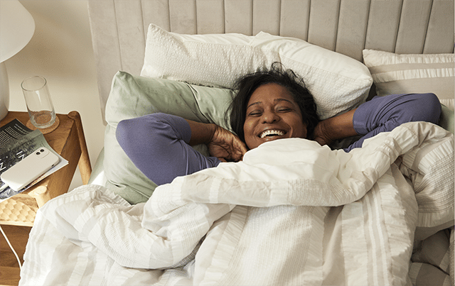 A woman waking up in her bed smiling 