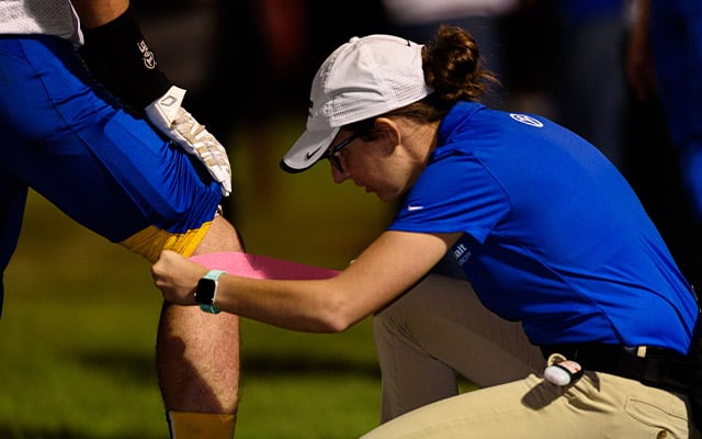 Reid Health's Athletic Trainer, Hannah Gross working on an athlete 