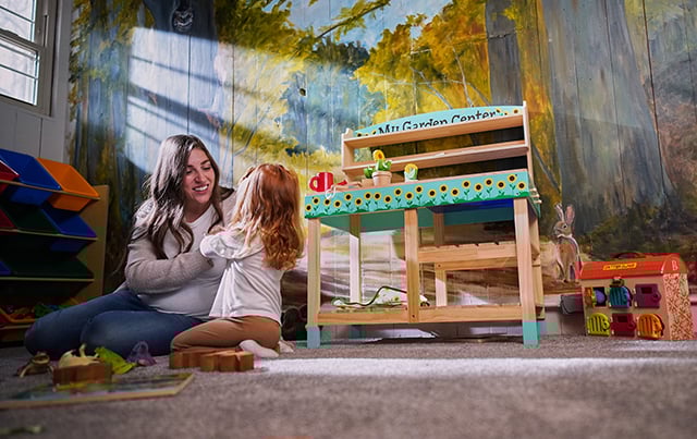 An image of a women sitting on the floor interacting with her child