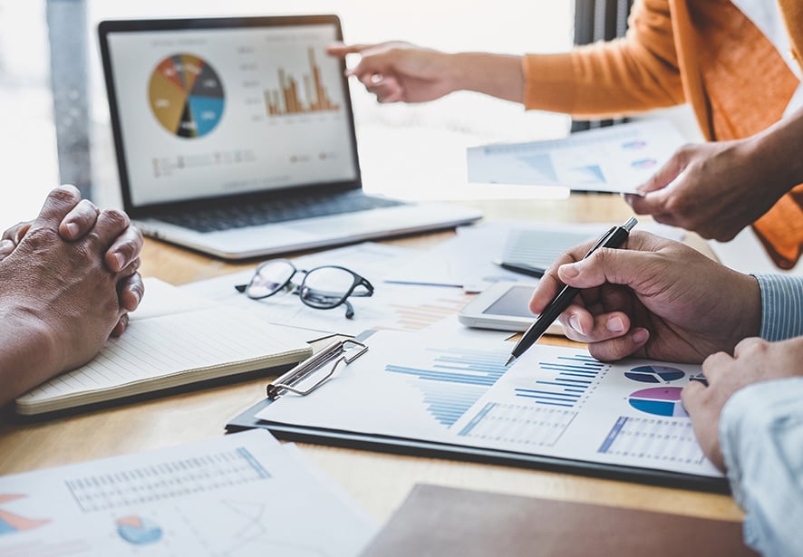 An image of people analyzing data with charts and graphs 