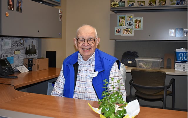 Blue Bridgae Volunteer Dudley sitting at a desk