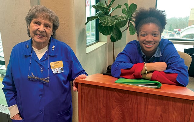 An adult volunteer working with a junior volunteer