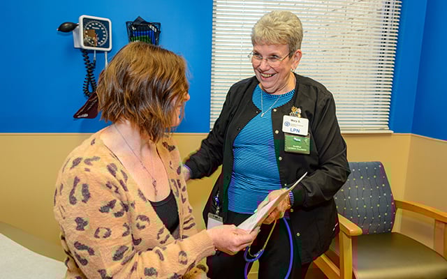 A Reid Health nurse giving a patient educational material