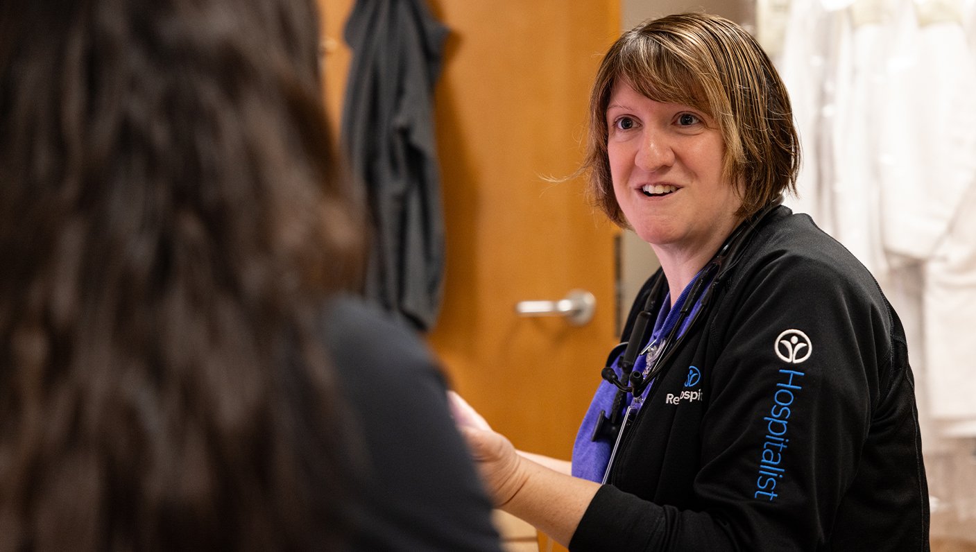 Hospitalist, Denna Medley conversing with another employee