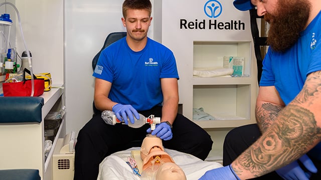 Two EMS trainees working in an ambulance simulator  