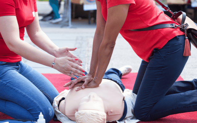 Photo is of an instructor leading a CPR demonstration for a student who is learning the technique. Reid Health offers CPR classes. 