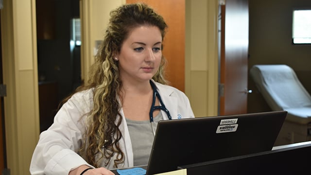 Dr. Megan Carpenter as a resident working on a computer 