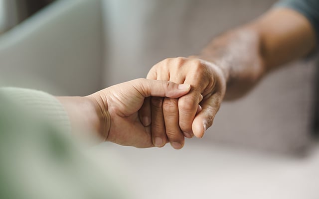 A close up image of two African Americas holding hands