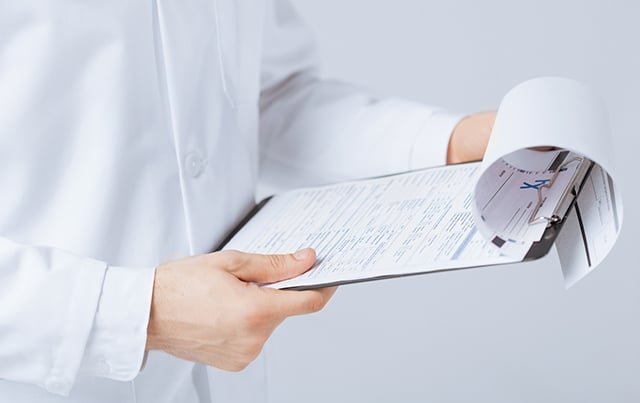 A medical provider holding a clip board with papers