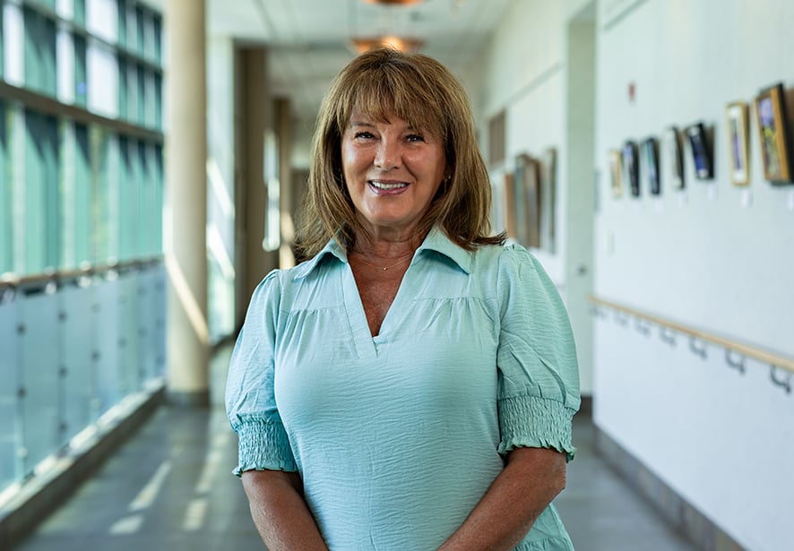 Kristen Britton, DO, Pediatrician at Reid Health, smiling while standing in a hospital corridor.