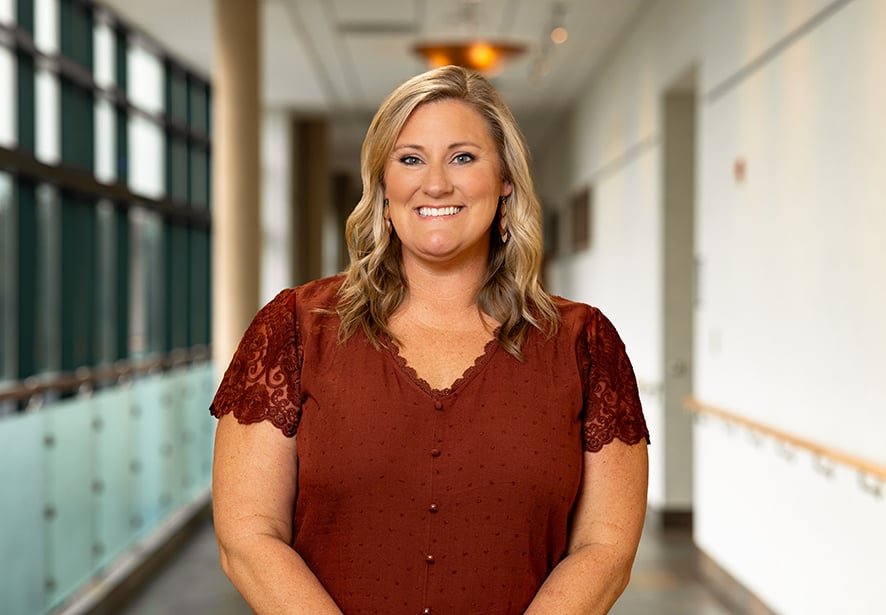 Katie Marker, NP, Primary Care Nurse Practitioner at Reid Health, smiling while standing in a hospital corridor.