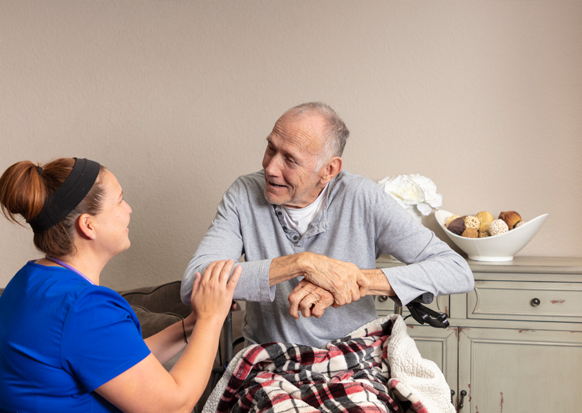 Provider kneels by patient and speaks with them