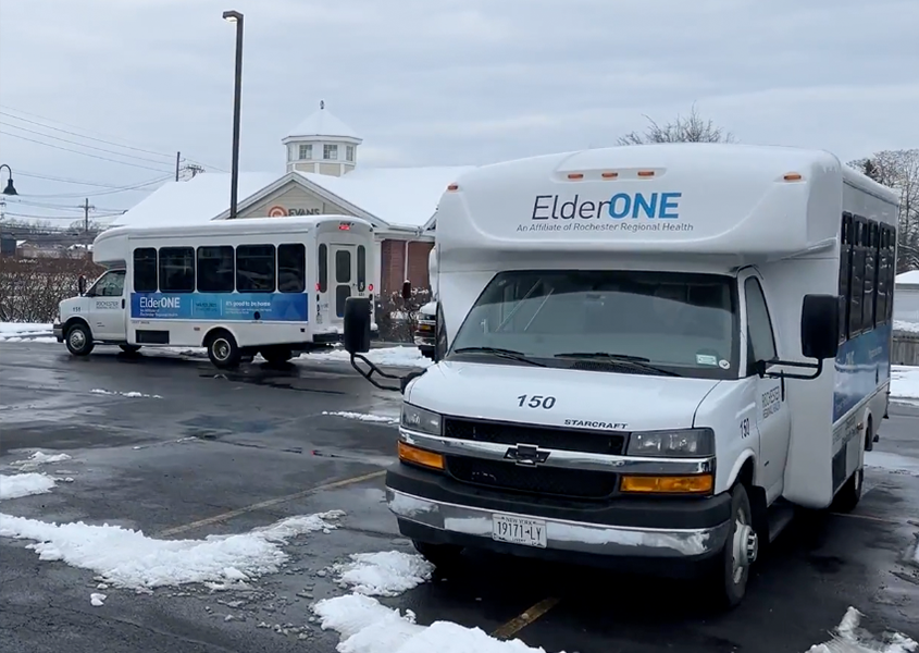 Two ElderONE Buses in a parking lot with snow