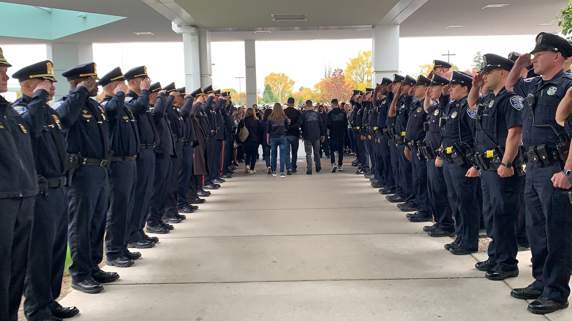 Police officers saluting Officer Denny Wright