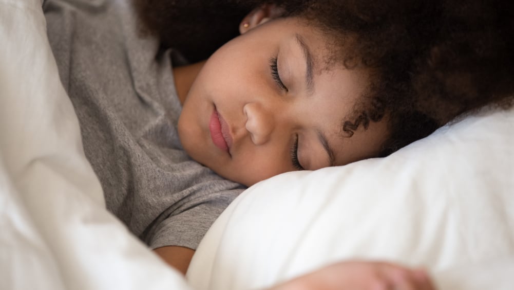 Young Black girl sleeps on pillow