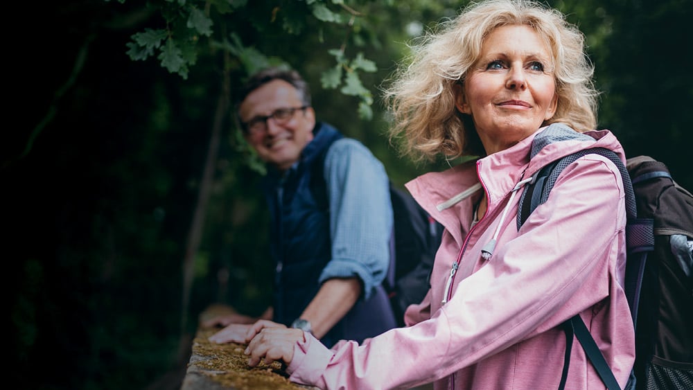 Middle aged woman in pink hiking jacket and middle aged man in blue hiking jacket