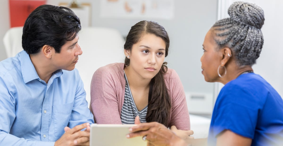A parent, young woman, and a provider discuss the young woman's health