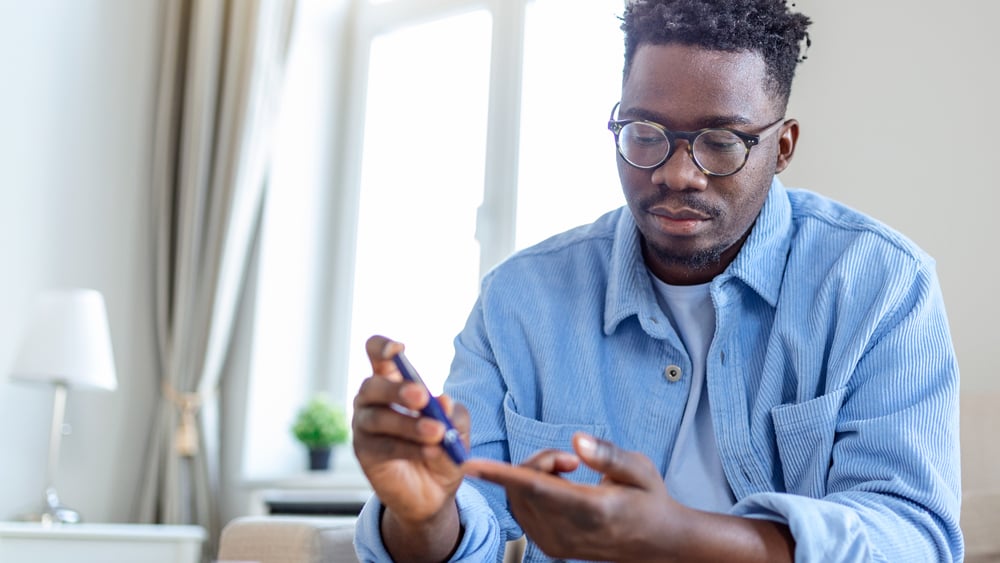 A Black man tests his insulin levels at home