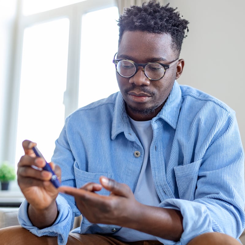 A Black man tests his insulin levels at home