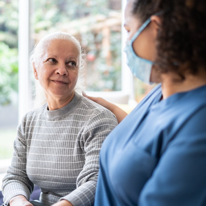 An older Black woman talks with a younger Black woman