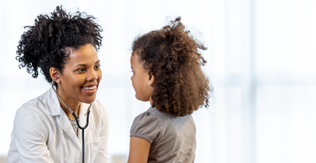 A Black pediatrician meets with a young Black girl