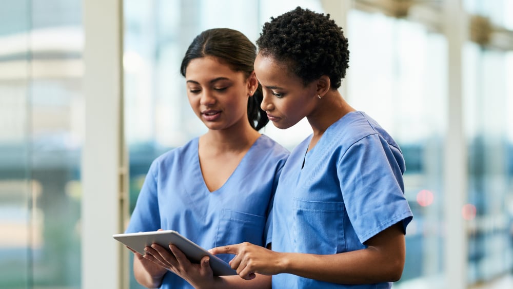 Two female physicians discuss a medical chart
