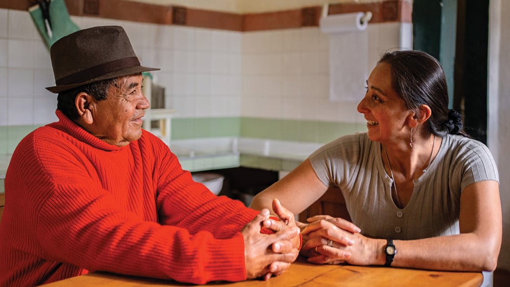 Elderly man sitting with adult daughter in kitchen