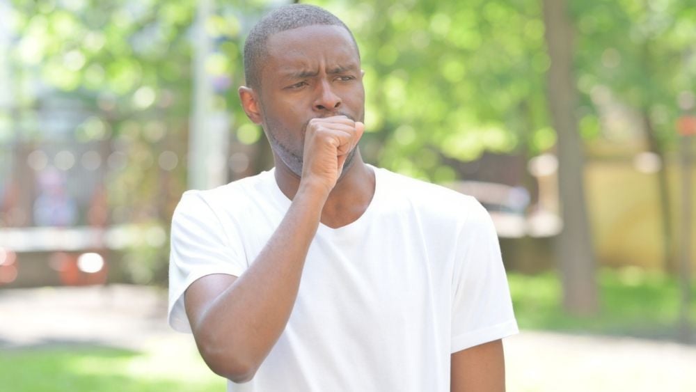 Black man coughing