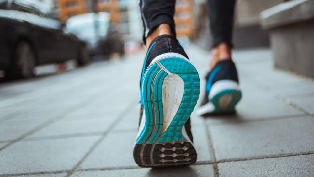 Running sneaker pushing off sidewalk midstride