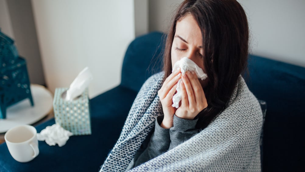 Woman sick with cold on couch