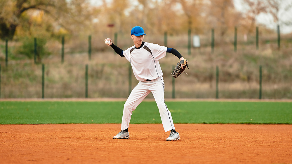 Teenage boy playing baseball