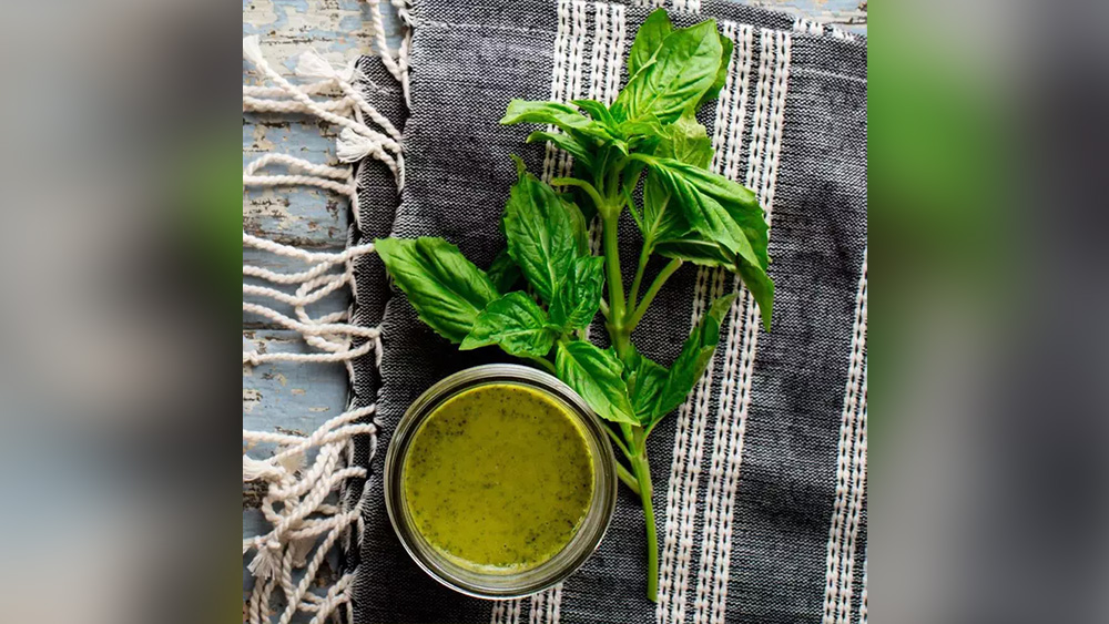 Basil vinaigrette dressing next to basil leaves